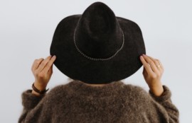 黒い帽子をかぶった茶色いセーターの女性